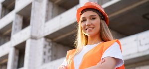 Técnica en Proyectos de Edificación con un casco y un chaleco frente a una obra