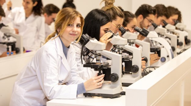 Mujeres mirando por un microscopio en el módulo de Anatomía Patológica y Citodiagnóstico